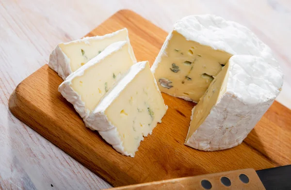 Obrázek plátků modrého sýra s plísní na dřevěné desce — Stock fotografie