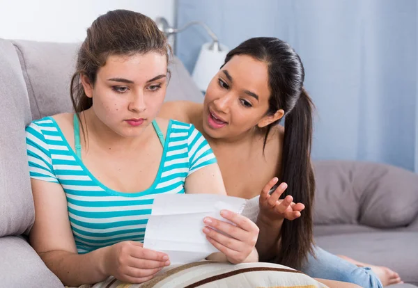 Teenagers girls reading letter on couch — Stock Photo, Image