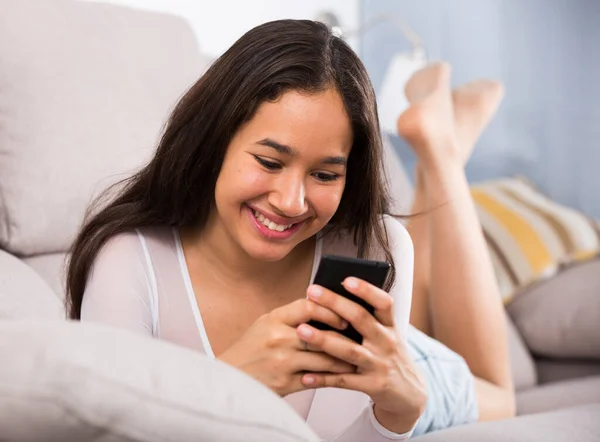 Jong blij vrouw liggend met mobiel — Stockfoto