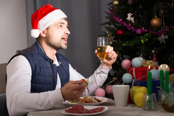 Junger Mann mit Hut feiert Neujahr beim Abendessen — Stockfoto