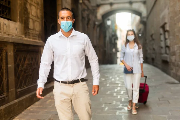 Jovem em máscara médica andando ao longo da rua da cidade — Fotografia de Stock