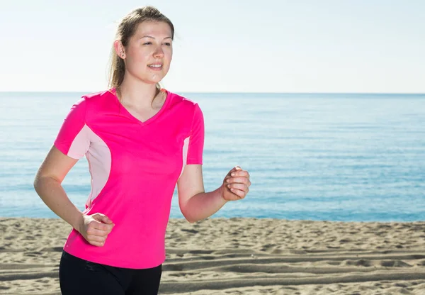 Svelte kvinna jogga på stranden — Stockfoto