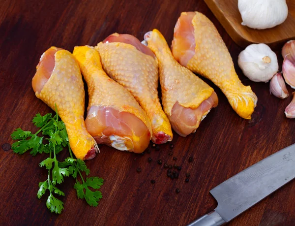 Syrové kuřecí stehýnka na řezací desce a talíři — Stock fotografie