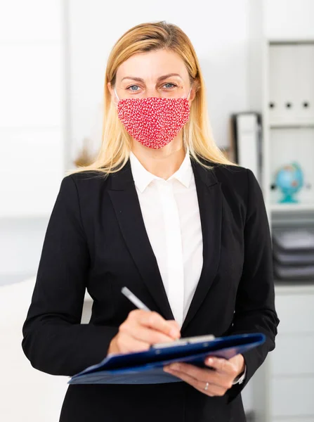 Mulher gerente em máscara médica no escritório durante o dia de trabalho — Fotografia de Stock