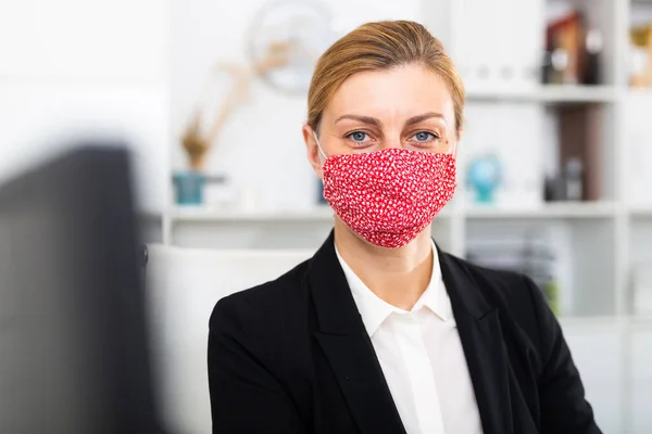 Kvinna manager i medicinsk mask på kontoret under arbetsdagen — Stockfoto