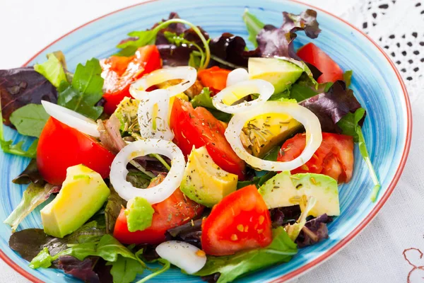 Placa con ensalada con rúcula, tomate y aguacate —  Fotos de Stock