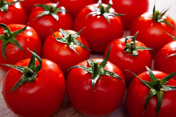 Close up van rijpe rode tomaten op houten ondergrond — Stockfoto