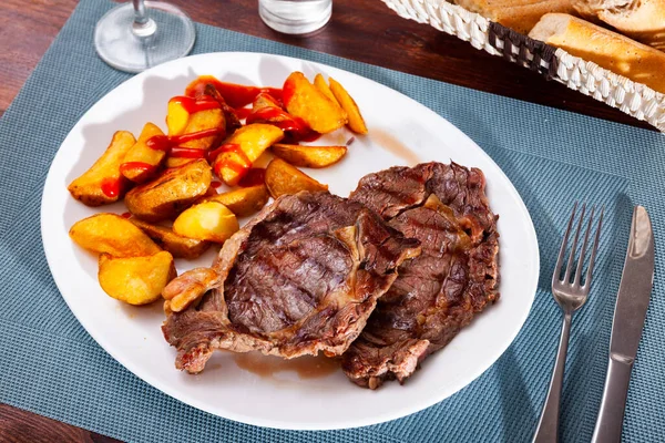 Entrecota de ternera con patatas asadas y salsa de tomate —  Fotos de Stock