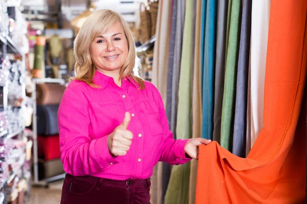 Mujer vendedor demostrando cortina y mostrando el pulgar hacia arriba —  Fotos de Stock