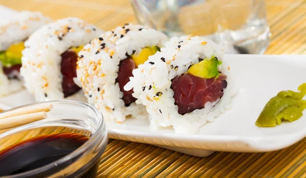 Heerlijke uramaki sushi met rauwe tonijn op bord met sojasaus — Stockfoto