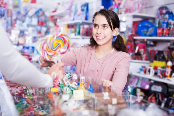 Colegiala comprar piruleta dulce —  Fotos de Stock