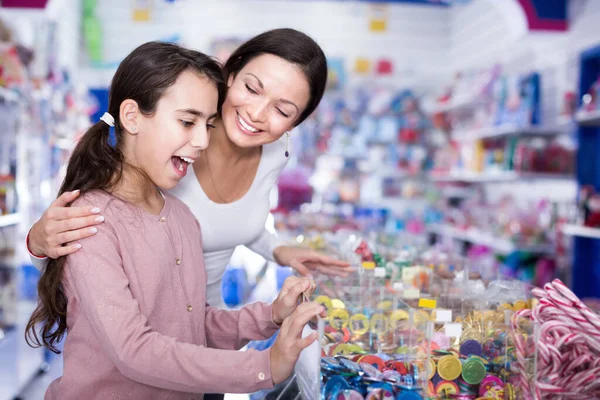 Smiling female and girl with open mouth buying sweet candies — Stock Photo, Image