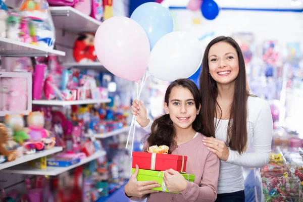 Anne ve kızın portresi mağazada hediyeler ve balonlar tutuyor. — Stok fotoğraf