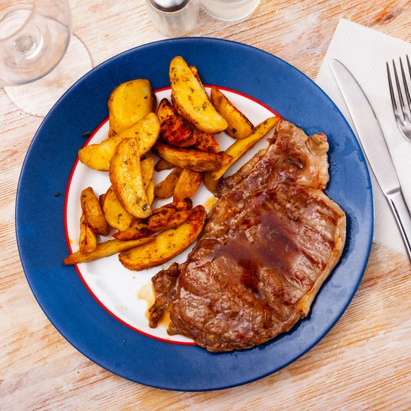 Sabroso bistec de ternera con papas al horno y ketchup —  Fotos de Stock