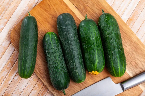 Fresh green juicy cucumbers on wooden table — Stock Photo, Image