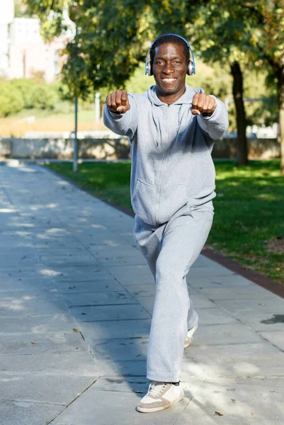 Ativo afro-americano fazendo exercícios no parque no dia ensolarado — Fotografia de Stock