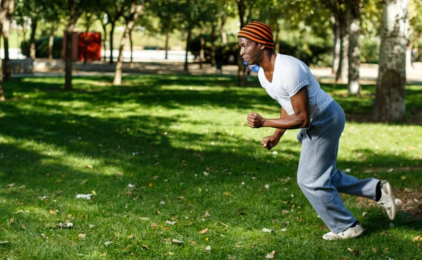 운동 선수인 아프리카계 미국인 공원에서 운동하는 동안 잔디 위를 뛰어다니는 미국 남자 — 스톡 사진