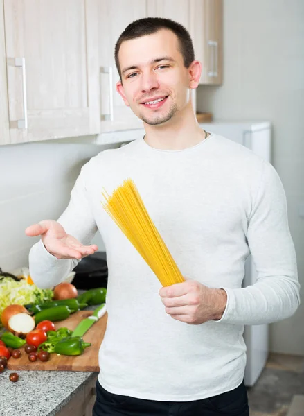 Mutfakta elinde spagetti tutan adam. — Stok fotoğraf