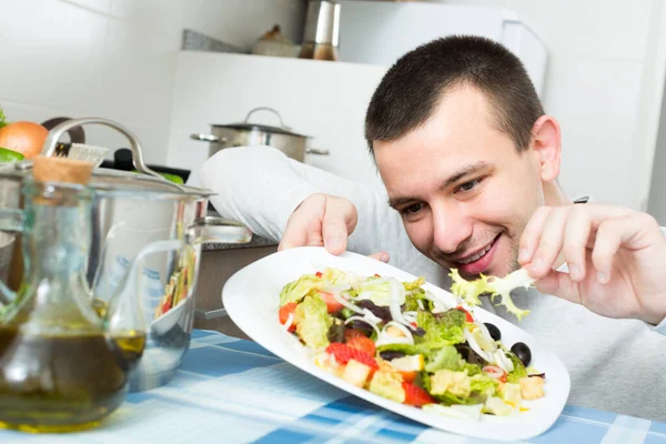 Guy decorando prato de salada em casa . — Fotografia de Stock