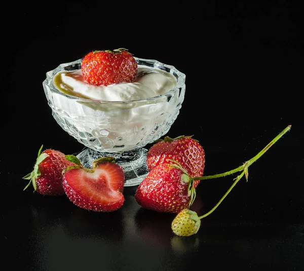 ripe strawberries in ice-cream bowl in dark