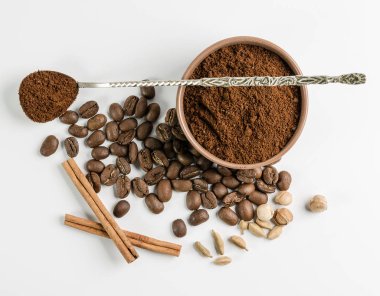 kahve çekirdeği ve beyaz zemin üzerine baharat ve kaşık kase çekilmiş kahve