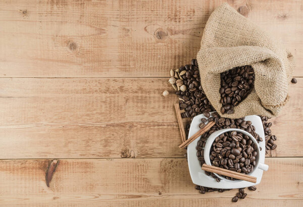 burlap bag with cofee beans and spices on wooden table