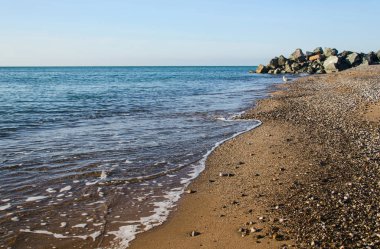 Günbatımı buzlu ile deniz ve çakıl plaj
