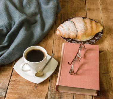 kahve kruvasan plaka ve kitap ile gözlük ve ekose ahşap tablo