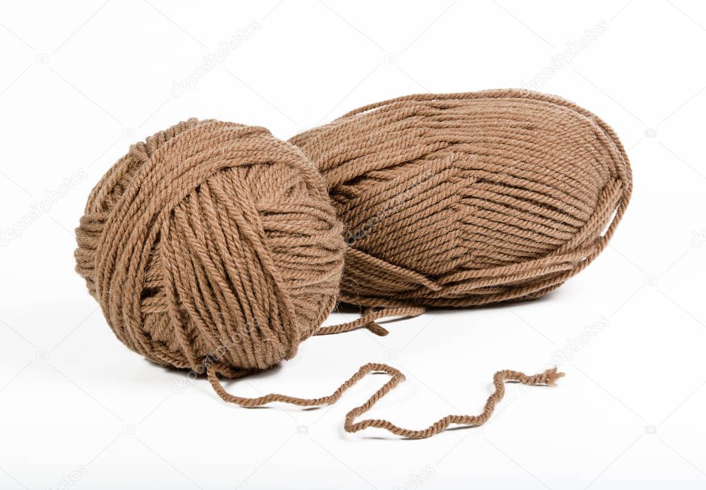 hanks of soft brown yarn on white background