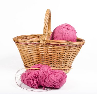 beyaz zemin üzerinde bir hasır sepet pembe iplik