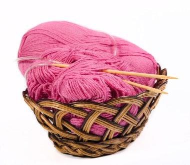 beyaz zemin üzerinde bir hasır sepet pembe iplik