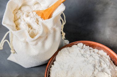 tahıl unu seramik kase ve koyu arka plan üzerine kaşıkla çanta