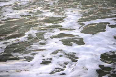 Dalgalar deniz kıyısında beyaz sprey