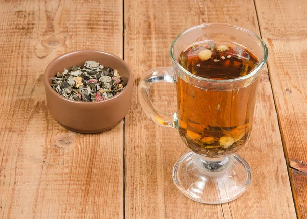 木桌上的一杯凉茶和一罐干凉茶 — 图库照片
