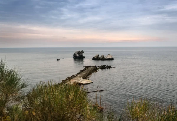 Útesy v moři a molo — Stock fotografie