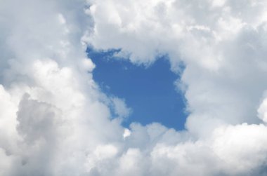 Bulutlarda delik. Güzel beyaz bulutların üstünde merkezinde delikli mavi gökyüzü.