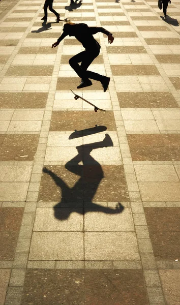 Silhouette of skateboarder skateboarding at sunrise city town.