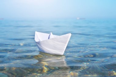 Kağıt oyuncak gemi ve derin mavi deniz. Kavramsal tasarım.