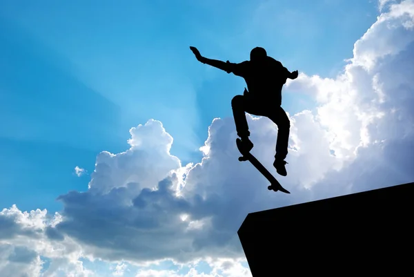 Sílhueta de salto de patinador e céu azul . — Fotografia de Stock