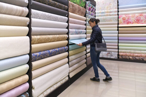 Girl chooses wallpaper 