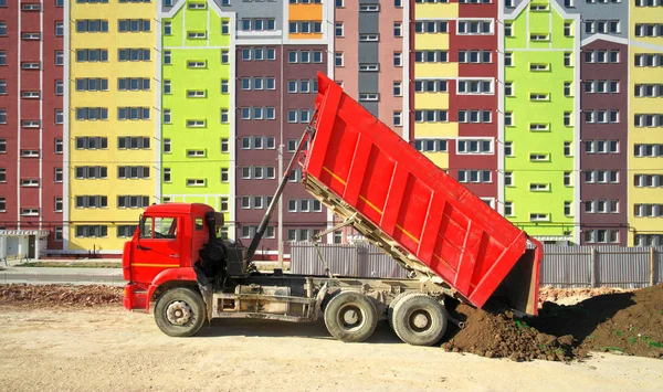 Multistorey building apartment house and dump truck unload soil. — Stock Photo, Image