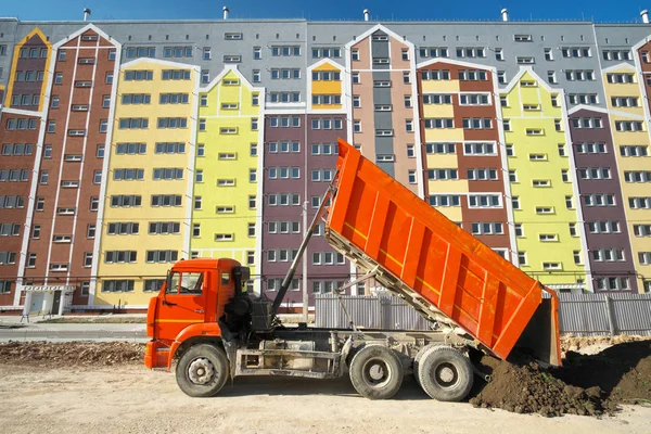 Multistorey building apartment house and dump truck unload soil. — Stock Photo, Image