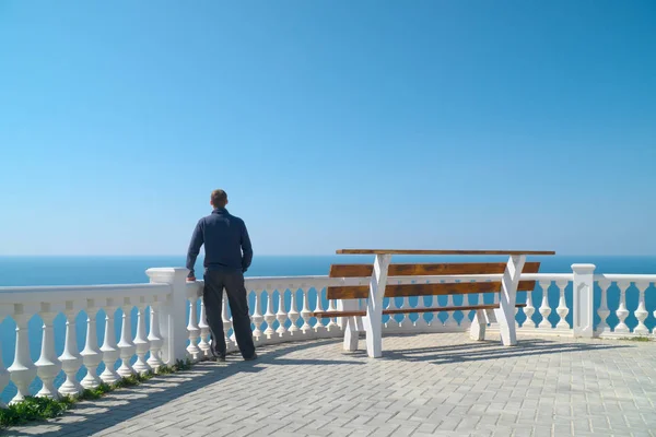 Man standing on balcony and look on the sea — Stock Photo, Image