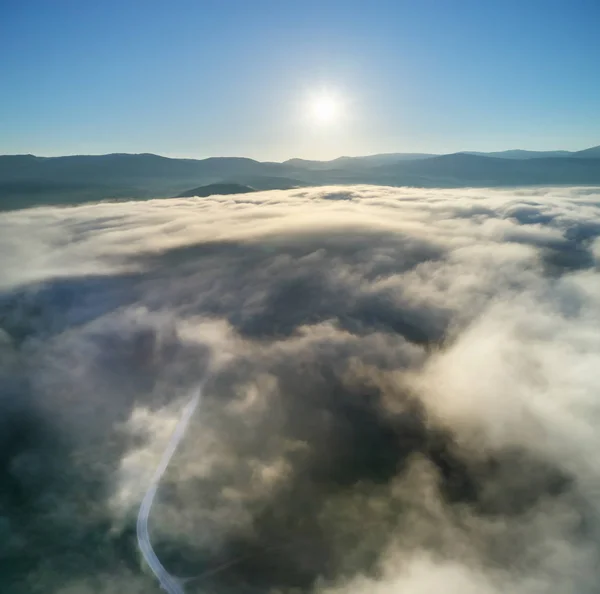 Nebbia in montagna e strada di mattina — Foto Stock