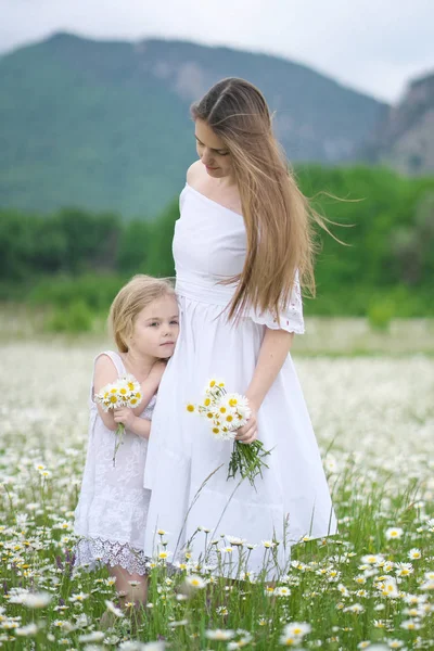 Šťastná matka a dcera v heřmánkového louce. — Stock fotografie
