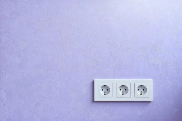 Wall socket and violet wall.