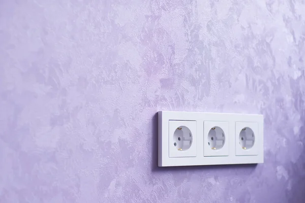 Vägguttag och violett vägg. — Stockfoto