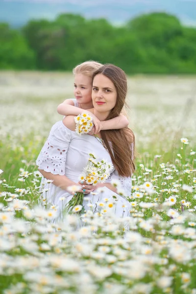 Papatya çayırında mutlu anne ve kızı.