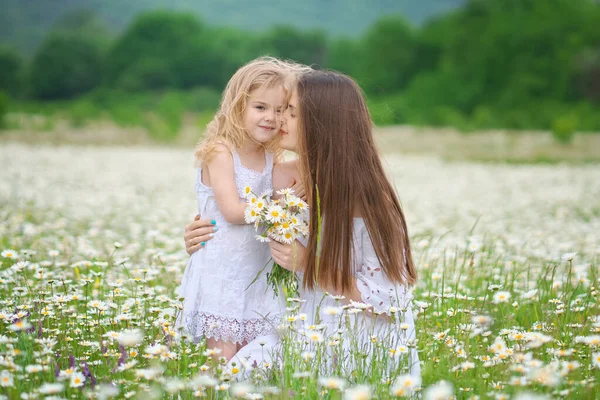 Feliz madre e hija en el prado de manzanilla . — Foto de Stock