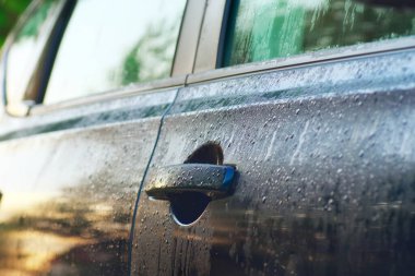 Sabah ışığında ıslak araba kapısı. Alanın yakın çekim ve sığ defekti. 
